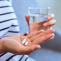 patient holding oral conscious sedation in hand 